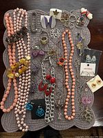 Overview of entire lot on mat showing necklaces, bracelets, earrings, brooches