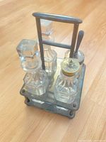 Full cruet set on stand showing all four bottles and metal frame