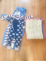Lot overview showing bunting, two sleepers, folded crocheted blanket