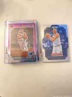 Front view of sleeved stack showing Michael Porter Jr. NBA Hoops purple holo and Nikola Jokić Prizm Monopoly card