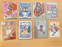 Front view of eight sleeved football QB cards