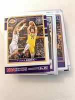 Stack of sleeved Lakers cards, top card Luka Dončić NBA Hoops 24-25