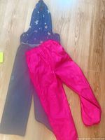 All three items laid out: grey MEC snow pants, navy star hoodie, pink rain pants