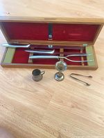 Open walnut case with carving set plus cup, vase, tongs