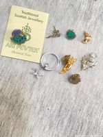 Overhead view of eight assorted pins, brooches, keyring and Art Pewter card