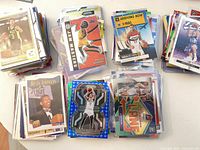 Stacks of assorted NBA trading cards showing Jam Masters Donovan Mitchell, Kevin Johnson, cracked-ice parallel, mosaic and others
