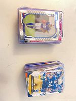 Two stacks of sleeved football cards on table, top card Buffalo Bills rookie, visible protective top-loaders