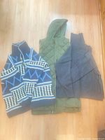 All three garments laid out: vest, cardigan, sweater