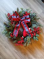 Top view of artificial wreath showing bow, berries and pinecones