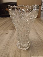 Front view of clear cut glass vase showing scalloped rim and cut patterns