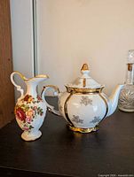 Teapot with lid and decorative pitcher side by side