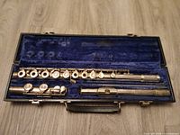 Flute disassembled in blue-lined hard case showing keys and joints