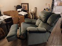 Recliner side view with footrest extended showing overall design and green fabric