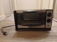 Front view of HomeStyles MG12DX toaster oven with power cord visible