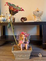 Full view of figurine lamp showing fairy in planter base and tall fabric flower shade