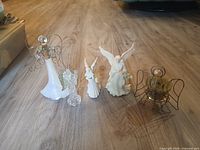 Front view of all five angel figurines and wire frame displayed on floor