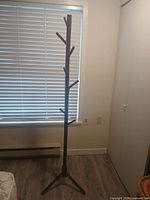 Full view of wooden coat rack standing in room