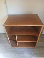 Front view of solid wood bookcase showing shelving configuration and casters