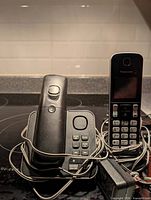 Front view of Panasonic handset on answering-machine base and second handset on charging cradle with attached power adapters