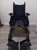 Front view of wheelchair showing seat, armrests, footrests