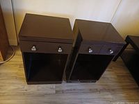 Two dark brown nightstands front view showing drawers and shelves