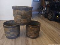 Three round wicker planter baskets stacked to show exterior weave