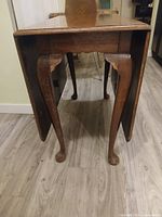 End view showing one drop leaf down, cabriole legs, pad feet, wear on edges
