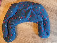 Blue floral U-shaped neck pillow on wood floor