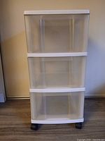 Front view of white clear plastic 3-drawer unit on black casters