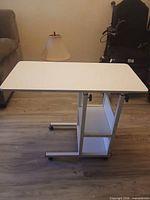 Table full view from left showing top, shelves, base and casters