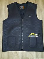 Front view of black heated vest with power bank in pocket