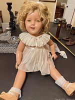 Full view of Shirley Temple doll seated in original outfit