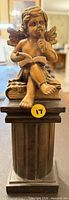 Front view of cherub figurine on pedestal