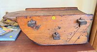 side profile of wooden sleigh showing curved body and hardware