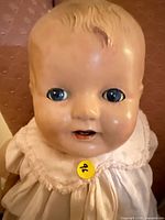 Close-up of doll face showing blue eyes, molded hair, paint wear