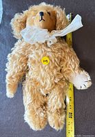 Full view of caramel mohair teddy bear with measuring tape showing 13.5 in height