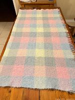 Full view of pastel plaid lap throw on table