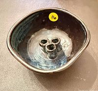 Top view of dark blue ceramic flower frog with number sticker