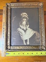 Front view showing sepia print and ornate frame with ruler for scale