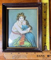 Front view of framed reproduction print showing image and frame with ruler for scale