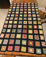 Full view of the granny square throw laid flat on table