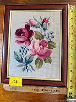 Front view showing entire framed needlepoint and measuring tape