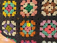 Close-up of multicolor granny squares with black surround
