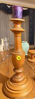 Full view of wood candlestick with purple candle