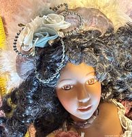 Close-up of doll’s face, hat and hair