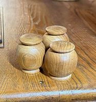 Three shakers on wooden table top showing overall design and color