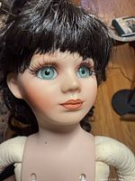 Close view of doll face showing vinyl head, eye color, hair, painted features
