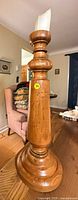 Full view of the tall turned wood candlestick with candle inserted