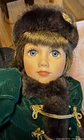 Close-up of doll face, hat, coat collar