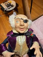 Front view of doll head and upper body showing porcelain features, eyepatch, clothing details
